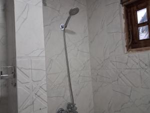 a shower in a bathroom with a stone wall at Slayan properties in Mudungoda