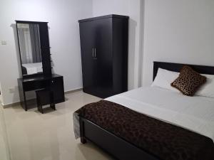 a bedroom with a bed and a dresser and a mirror at Slayan properties in Mudungoda