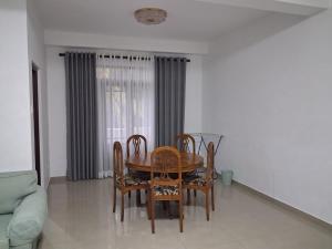 a dining room table and chairs in a living room at Slayan properties in Mudungoda