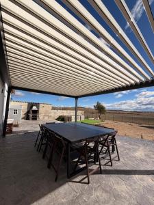 a picnic table under awning on a patio at Campos de Villalba in Villalba