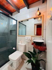 a bathroom with a toilet and a sink at Recanto Porto Chalé e SPA in Penha