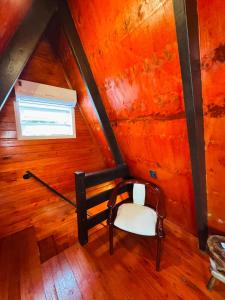an attic room with a bench and a window at Recanto Porto Chalé e SPA in Penha