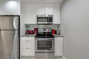 a kitchen with a stove and a microwave at Vibrant Stylish, Cozy Waterfront Downtown in Calgary +16 photos