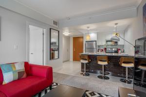 a living room with a red couch and a kitchen at Vibrant Stylish, Cozy Waterfront Downtown in Calgary