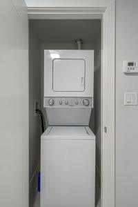 a white refrigerator with a microwave on top of it at Vibrant Stylish, Cozy Waterfront Downtown in Calgary