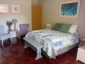 a bedroom with a bed and a table and chairs at Sunshine Cottage in Fish Hoek