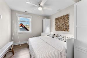 a white bedroom with a bed and a window at 921 Asbury Ave, Unit C in Ocean City