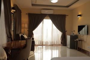 a living room with a table and a large window at Golden Alpine Hotel in Yola