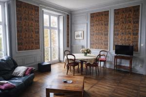 a living room with a table and chairs and a couch at L'intemporel, gîte de charme pour 4 à 5 personnes in Saint-Gervais-la-Forêt