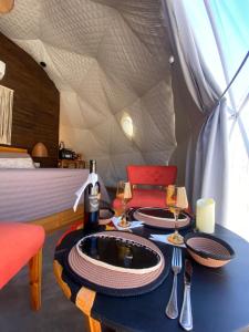 a room with a table with wine glasses and a bed at Tinku Huasi Domos Suite in Tilcara +27 photos