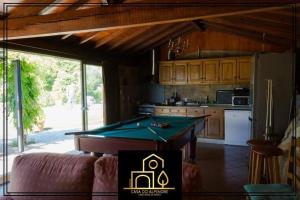 a kitchen with a pool table in a room at Casa do Alpendre in Arco de Baúlhe