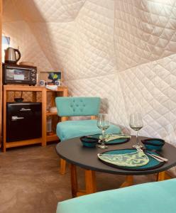 a dining room with a table and two wine glasses at Tinku Huasi Domos Suite in Tilcara