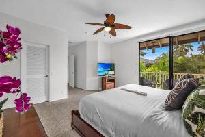 a bedroom with a bed and a tv and a balcony at Grand Champions 124 · GC 124 3BD Wailea Condo wAC Pool Hot Tub in Wailea +45 photos