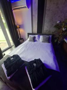 a bedroom with a white bed with purple lighting at SECRET LOVE studio in Ełk