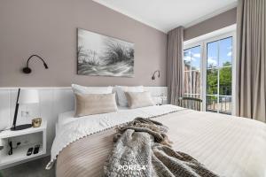 a white bedroom with a large bed with a window at Ferienwohnung TheViewB17 Boje 17 Dagebüll in Dagebüll