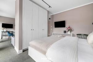 a white bedroom with a large bed and a desk at Ferienwohnung TheViewB17 Boje 17 Dagebüll in Dagebüll