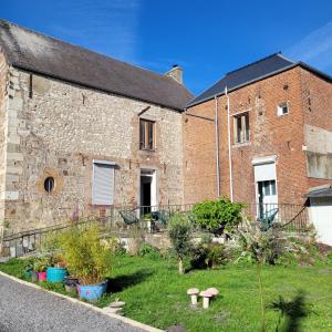 an old brick building with a garden in front of it at Vallee du Ton in Origny-en-Thiérache