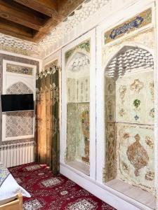 a room with a wall covered in persian carpet at Boutique ALISHER in Bukhara
