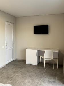 a desk with a chair and a television on a wall at Hotel Elena Solotvino in Solotvyno