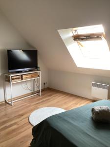 a bedroom with a flat screen tv and a bed at Chez Nathou in Janzé