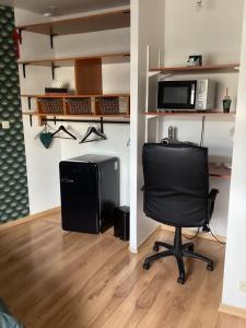 a room with a chair and a microwave at Chez Nathou in Janzé