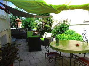 a patio with a table and chairs and an umbrella at La Pause in Craponne