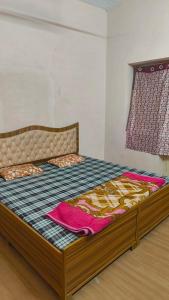 a bedroom with a bed with a wooden frame at Arihant Guest House in Ujjain