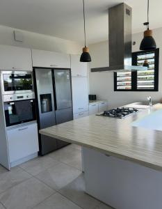 a kitchen with white appliances and a counter top at Villa chandelle in Saint-Pierre