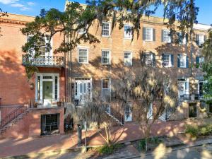 a large brick building with a tree in front of it at Oglethorpe Estate in Savannah