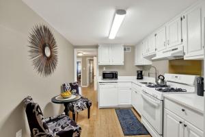 a kitchen with white cabinets and a table and chairs at Oglethorpe Estate in Savannah