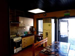 a kitchen with a refrigerator and a table in it at Hostel Lagos del Sur in El Chalten