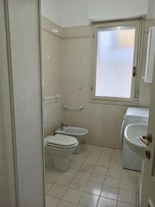 a bathroom with a toilet and a sink and a window at Colibrì in Bordighera