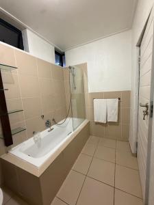 a bathroom with a bath tub and a shower at The Greenside Getaway in Roodepoort