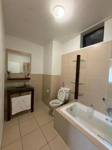 a bathroom with a tub and a toilet and a sink at The Greenside Getaway in Roodepoort