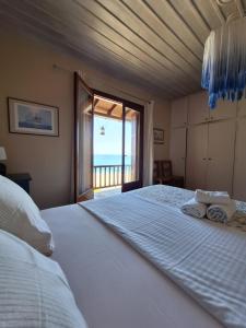 a bedroom with a large bed with a view of the ocean at Papa Nero Beach House in Agios Ioannis Pelio