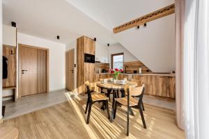 a kitchen and dining room with a table and chairs at Pokoje KAMILA - Apartament 5 min pieszo do Kotelnicy in Białka Tatrzańska