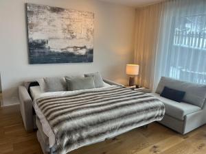 a bedroom with a bed and a couch at Apartment EMILY Brixental in Brixen im Thale