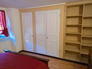 a closet with white doors and shelves in a room at Il Nido sul Torrente in Coazze