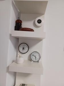 three clocks sitting on shelves in a room at Lorea Puerto in Puerto de Sagunto