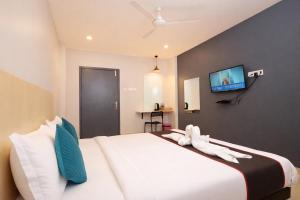a bedroom with a large white bed with a flat screen tv at RJB Grand in Guwahati