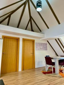 a room with two wooden doors and a table at The Pine Loft by Kopaonik in Kopaonik