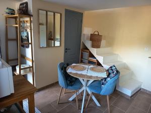 a table and chairs in a room with stairs at Le refuge de Teddy in Solliès-Toucas