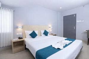 a bedroom with a large white bed with blue accents at RJB Grand in Guwahati +46 photos