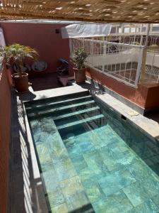 a swimming pool with some plants on a balcony at Riad DIHYA & Rooftop Pool in Marrakesh