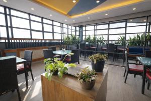 a restaurant with tables and chairs and plants at RJB Grand in Guwahati