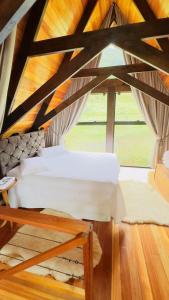 a bed in a room with a large window at Chalet Relaggio in Encantado