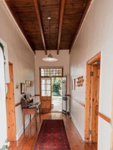 a hallway with a table and a desk in a house at Cypress Cottage - The Old House at River Bend in Graaff-Reinet