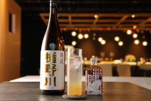 a bottle of beer and a glass on a table at Tsukino HOTEL in Sakata