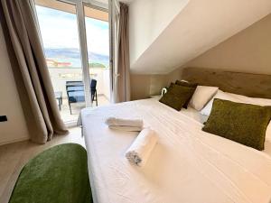 a bedroom with a white bed with a large window at Apartment Anchor Luxury in Slatine +143 photos
