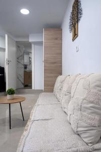 a white couch in a living room with a table at Olive tree studio ,Corfu Town in Ágios Rókkos